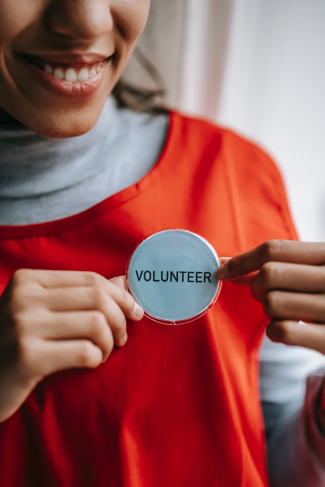 A girl in red clothes with a "volunteer" badge